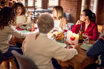 Beautiful group of women smiling happy and confident. Eating roasted turkey celebrating christmas at home