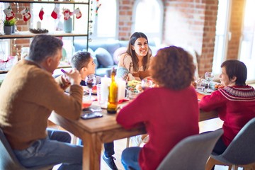 Beautiful family smiling happy and confident. Eating roasted turkey celebrating christmas at home