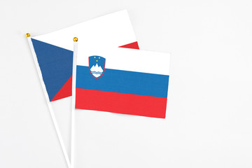 Slovenia and Cyprus stick flags on white background. High quality fabric, miniature national flag. Peaceful global concept.White floor for copy space.