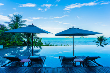 Umbrella and chair around beautiful luxury outdoor swimming pool with sea ocean view in hotel resort for holiday vacation travel