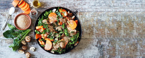 Cooking vegan wheat porridge with vegetables and mushrooms. Vegan dish before cooking. Carrots, wheat groats, champignons, spinach, spices.