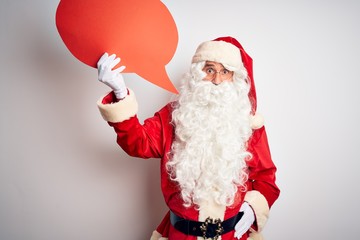 Middle age man wearing Santa costume holding speech bubble over isolated white background scared in shock with a surprise face, afraid and excited with fear expression