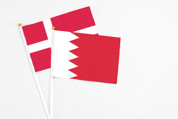 Bahrain and Denmark stick flags on white background. High quality fabric, miniature national flag. Peaceful global concept.White floor for copy space.