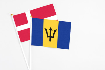 Barbados and Denmark stick flags on white background. High quality fabric, miniature national flag. Peaceful global concept.White floor for copy space.