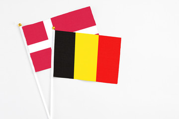 Belgium and Denmark stick flags on white background. High quality fabric, miniature national flag. Peaceful global concept.White floor for copy space.