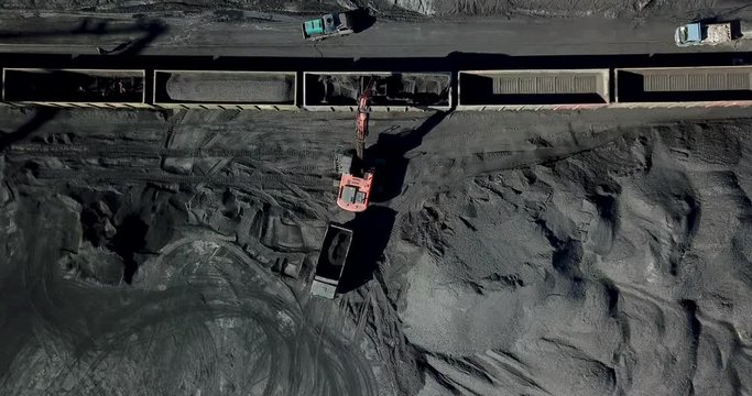View from above. Coal port. The excavator is engaged in loading coal into railway cars.