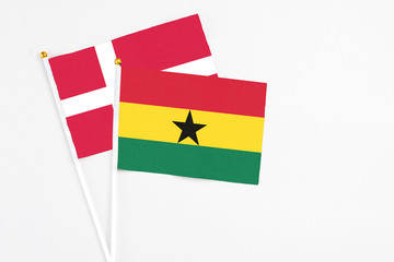 Ghana and Denmark stick flags on white background. High quality fabric, miniature national flag. Peaceful global concept.White floor for copy space.