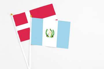 Guatemala and Denmark stick flags on white background. High quality fabric, miniature national flag. Peaceful global concept.White floor for copy space.