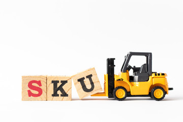 Toy forklift hold wood letter block U to complete word SKU (abbreviation of stock keeping unit) on white background