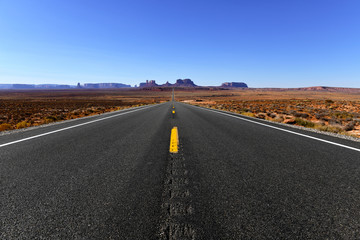 Road into the red rock desert landscape of Monument Valley, Navajo Tribal Park in the southwest USA in Arizona and Utah