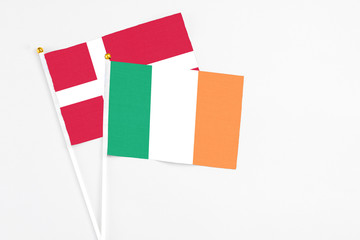 Ireland and Denmark stick flags on white background. High quality fabric, miniature national flag. Peaceful global concept.White floor for copy space.
