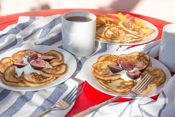 Breakfast of delicious homemade pancakes with fresh figs and tea