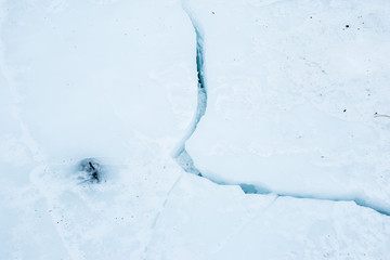 crack on the ice close-up on the winter river. Ice background.