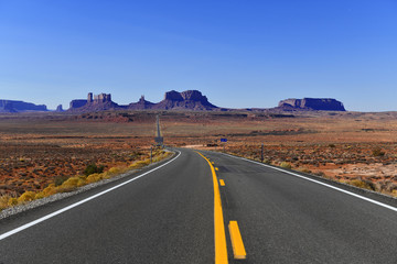 Fototapeta na wymiar Road into the red rock desert landscape of Monument Valley, Navajo Tribal Park in the southwest USA in Arizona and Utah