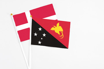 Papua New Guinea and Denmark stick flags on white background. High quality fabric, miniature national flag. Peaceful global concept.White floor for copy space.