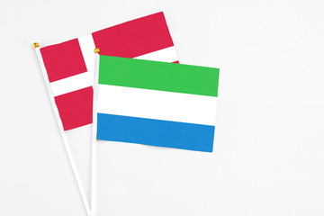 Sierra Leone and Denmark stick flags on white background. High quality fabric, miniature national flag. Peaceful global concept.White floor for copy space.