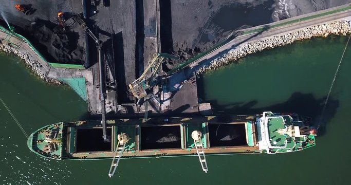 Coal port. Flying over a coal port in the small town of Nakhodka. Coal loading on a cargo ship in the sea coal port.