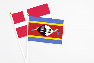 Swaziland and Denmark stick flags on white background. High quality fabric, miniature national flag. Peaceful global concept.White floor for copy space.