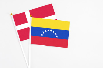 Venezuela and Denmark stick flags on white background. High quality fabric, miniature national flag. Peaceful global concept.White floor for copy space.