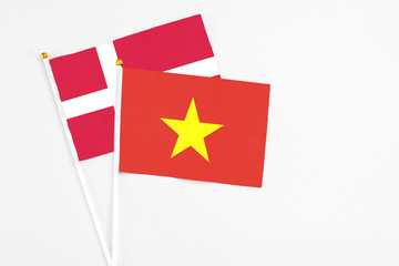 Vietnam and Denmark stick flags on white background. High quality fabric, miniature national flag. Peaceful global concept.White floor for copy space.