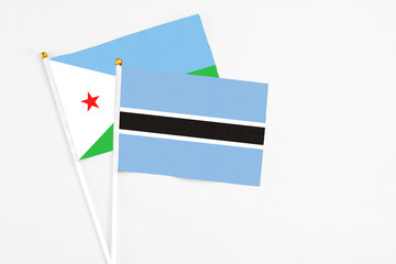 Botswana and Djibouti stick flags on white background. High quality fabric, miniature national flag. Peaceful global concept.White floor for copy space.