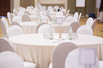 Selective focus of Paper, pencil, water bottle, glass  on the table in the seminar room background