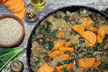 Vegan wheat porridge with vegetables and mushrooms. Vegan dish before cooking. Carrots, wheat groats, champignons, spinach, spices.