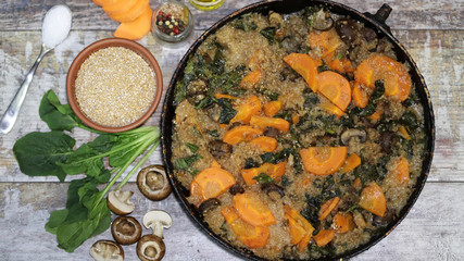 Vegan wheat porridge with vegetables and mushrooms. Vegan dish before cooking. Carrots, wheat groats, champignons, spinach, spices.