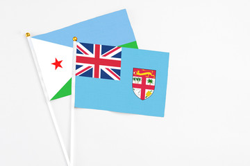 Fiji and Djibouti stick flags on white background. High quality fabric, miniature national flag....