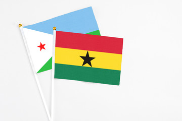 Ghana and Djibouti stick flags on white background. High quality fabric, miniature national flag. Peaceful global concept.White floor for copy space.