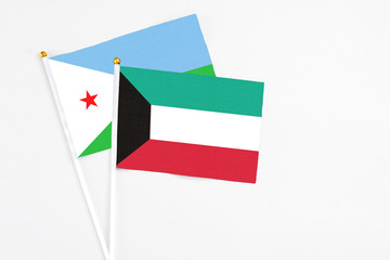 Kuwait and Djibouti stick flags on white background. High quality fabric, miniature national flag. Peaceful global concept.White floor for copy space.