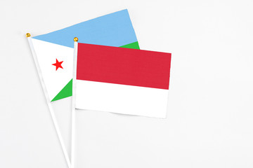 Monaco and Djibouti stick flags on white background. High quality fabric, miniature national flag. Peaceful global concept.White floor for copy space.