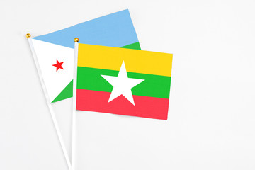 Myanmar and Djibouti stick flags on white background. High quality fabric, miniature national flag. Peaceful global concept.White floor for copy space.