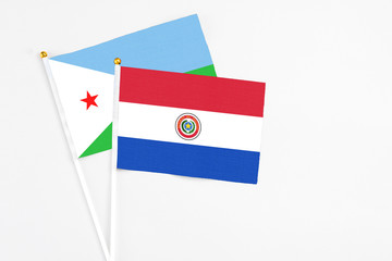 Paraguay and Djibouti stick flags on white background. High quality fabric, miniature national flag. Peaceful global concept.White floor for copy space.