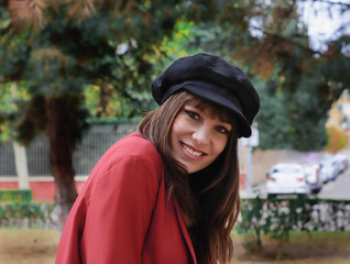 Beautiful young woman with red jacket and black cap
