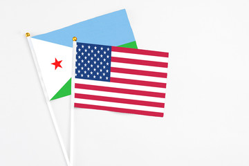 United States and Djibouti stick flags on white background. High quality fabric, miniature national flag. Peaceful global concept.White floor for copy space.