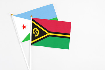 Vanuatu and Djibouti stick flags on white background. High quality fabric, miniature national flag. Peaceful global concept.White floor for copy space.