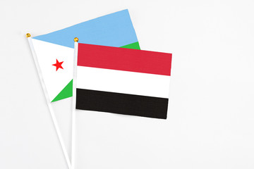 Yemen and Djibouti stick flags on white background. High quality fabric, miniature national flag. Peaceful global concept.White floor for copy space.