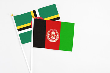 Afghanistan and Dominica stick flags on white background. High quality fabric, miniature national flag. Peaceful global concept.White floor for copy space.