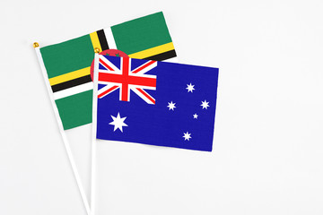 Australia and Dominica stick flags on white background. High quality fabric, miniature national flag. Peaceful global concept.White floor for copy space.