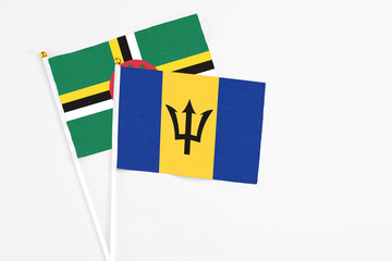 Barbados and Dominica stick flags on white background. High quality fabric, miniature national flag. Peaceful global concept.White floor for copy space.