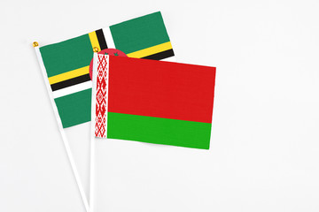 Belarus and Dominica stick flags on white background. High quality fabric, miniature national flag. Peaceful global concept.White floor for copy space.