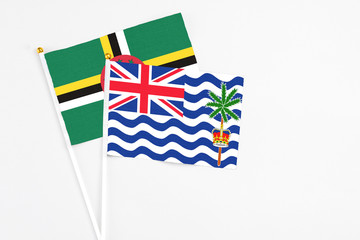 British Indian Ocean Territory and Dominica stick flags on white background. High quality fabric, miniature national flag. Peaceful global concept.White floor for copy space.