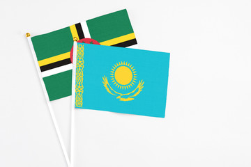 Kazakhstan and Dominica stick flags on white background. High quality fabric, miniature national flag. Peaceful global concept.White floor for copy space.