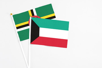 Kuwait and Dominica stick flags on white background. High quality fabric, miniature national flag. Peaceful global concept.White floor for copy space.