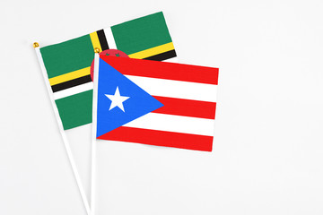 Puerto Rico and Dominica stick flags on white background. High quality fabric, miniature national flag. Peaceful global concept.White floor for copy space.
