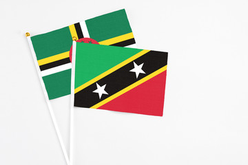 Saint Kitts And Nevis and Dominica stick flags on white background. High quality fabric, miniature national flag. Peaceful global concept.White floor for copy space.