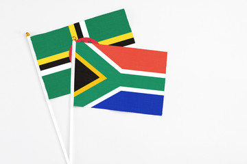 South Africa and Dominica stick flags on white background. High quality fabric, miniature national flag. Peaceful global concept.White floor for copy space.