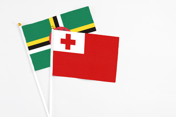 Tonga and Dominica stick flags on white background. High quality fabric, miniature national flag. Peaceful global concept.White floor for copy space.