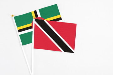 Trinidad And Tobago and Dominica stick flags on white background. High quality fabric, miniature national flag. Peaceful global concept.White floor for copy space.